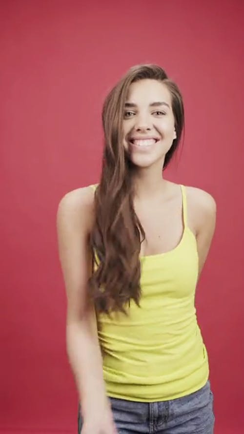 一个年轻女子在头顶的黄色顶部扔五彩纸屑 · 免费素材视频