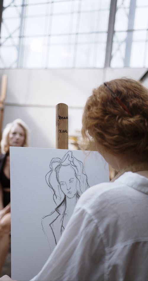 一个在画布上画一个女人的艺术家 · 免费素材视频