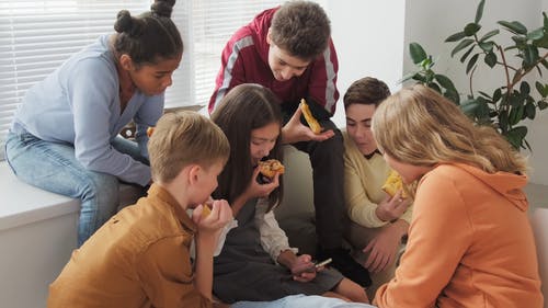 青少年在吃披萨时看着智能手机 · 免费素材视频