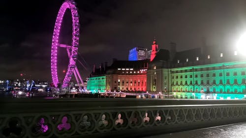 晚上在伦敦市政厅大楼后面的伦敦眼 · 免费素材视频