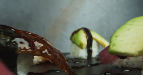 甜汁毛毛雨在混合寿司上 · 免费素材视频