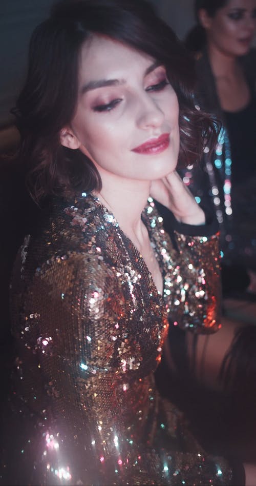 一个穿着金衣服跳舞的女人而坐 · 免费素材视频