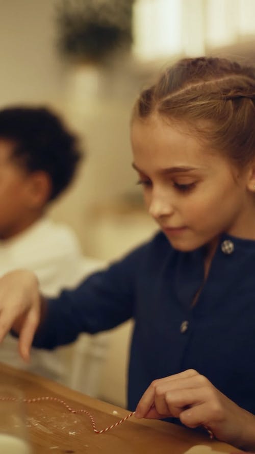 一个女孩在心形饼干上放一个字符串 · 免费素材视频