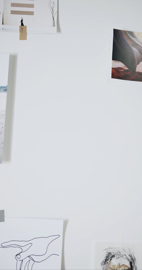 一个人在墙上贴上打印的图片 · 免费素材视频