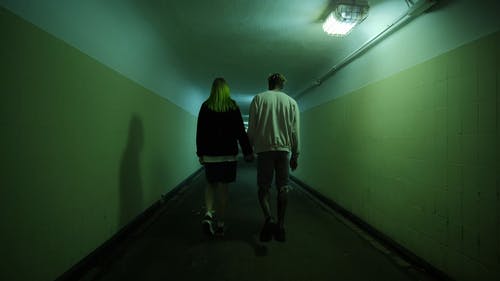 一对夫妇手牵着手走在地下通道的走廊上 · 免费素材视频