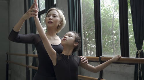 女人教她的学生在芭蕾舞中正确的姿势 · 免费素材视频