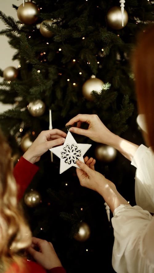 母亲和女儿挂在一棵圣诞树上的装饰品 · 免费素材视频
