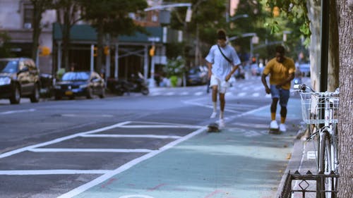两名年轻男子在街人行道上滑板 · 免费素材视频