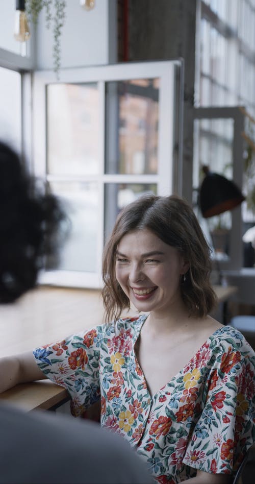 花衬衫喝咖啡时笑的女人 · 免费素材视频
