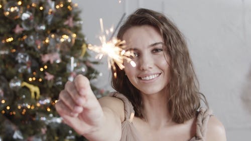 一个女人抱着一根点燃的棍子闪闪发光 · 免费素材视频