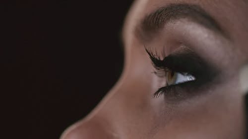 一个女人在她的眼底涂阴影化妆 · 免费素材视频