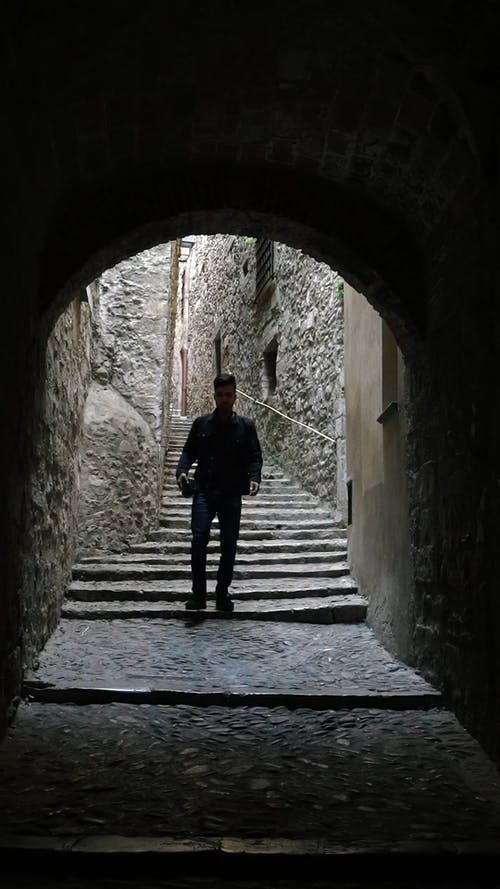 一个人走在狭窄的混凝土台阶，楼梯进入隧道 · 免费素材视频