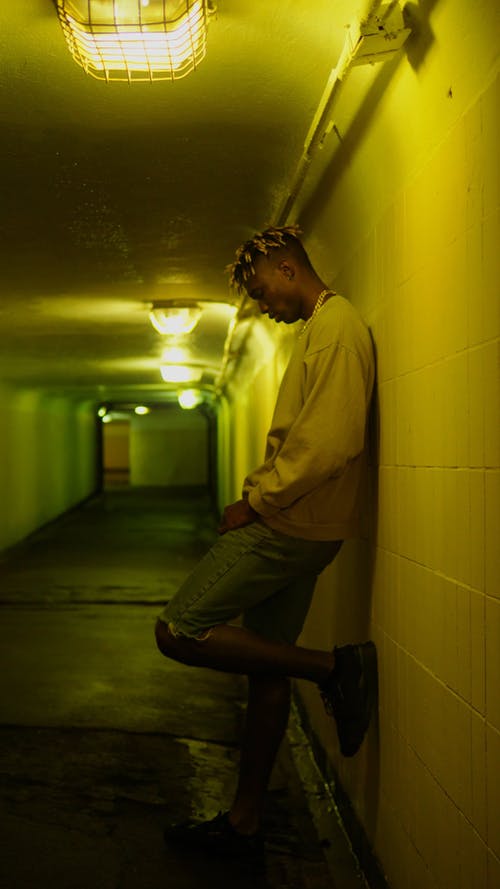 一个男人倚在地下通道的墙上 · 免费素材视频