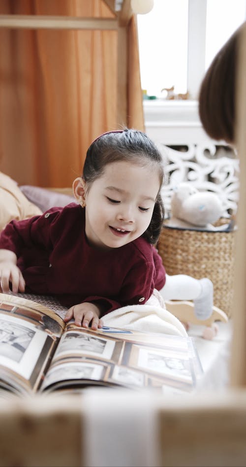 孩子们寻找和调皮地选择一本书中的图片 · 免费素材视频