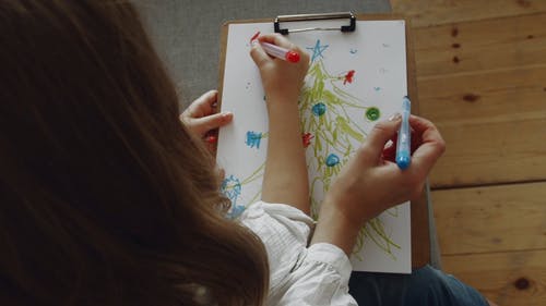一对母亲和女儿在彩色绘图中的一棵圣诞树 · 免费素材视频