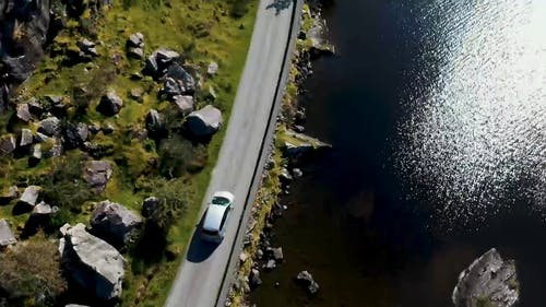 一辆汽车在湖边建的道路上行驶 · 免费素材视频