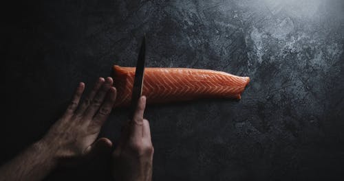 用刀从一块鲑鱼肉切片 · 免费素材视频