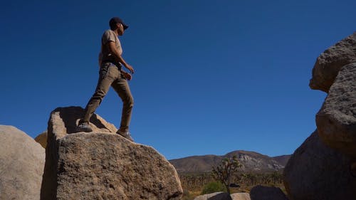 一个男人站在一块巨石上注意 · 免费素材视频