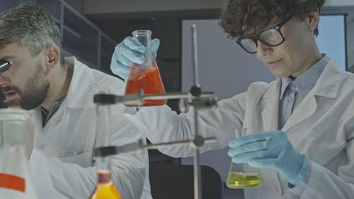 一个女人在实验室工作混合液体和获取样品 · 免费素材视频