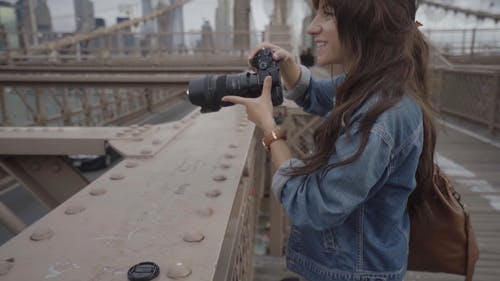 女摄影师在钢桥上拍照时 · 免费素材视频