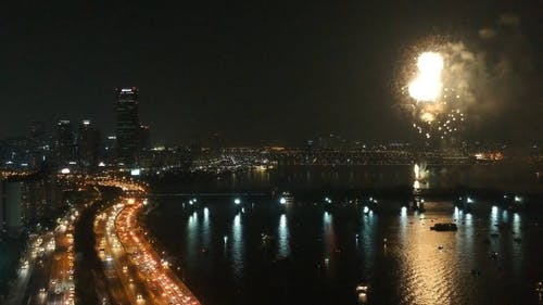 晚上在繁忙的城市的河上烟花汇演 · 免费素材视频