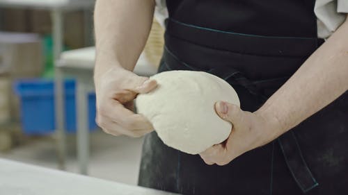 一位面包师在制作面团准备烘烤时显示出他的技能 · 免费素材视频