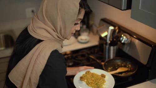 盖头的女人拿着黄色的米饭一盘 · 免费素材视频