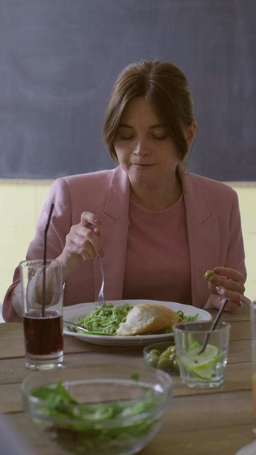 一个女人吃蔬菜沙拉和面包 · 免费素材视频
