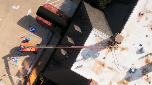 工人使用设备升降机在建筑物的屋顶上进行维护工作 · 免费素材视频