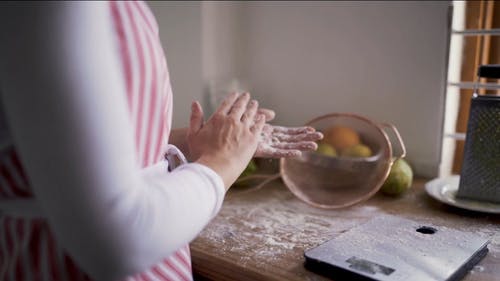 一个女人在烘烤时揉掉多余的面粉 · 免费素材视频