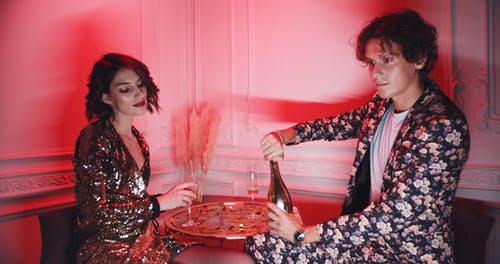 一对夫妇在迪斯科转角桌上喝香槟 · 免费素材视频
