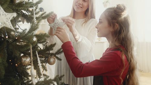 母亲和女儿挂在圣诞树上的装饰品装饰 · 免费素材视频