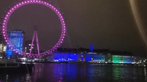 伦敦眼和夜晚背后的建筑物的彩灯显示 · 免费素材视频