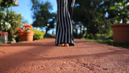 一个女人的脚赤脚在混凝土路面上跳舞 · 免费素材视频