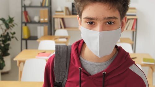 一个戴着口罩的男孩在学校 · 免费素材视频