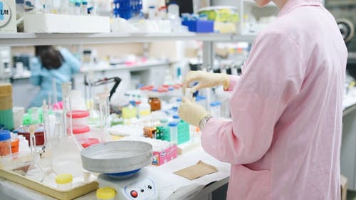 打开化学样品的粉红色实验室外套的女人 · 免费素材视频