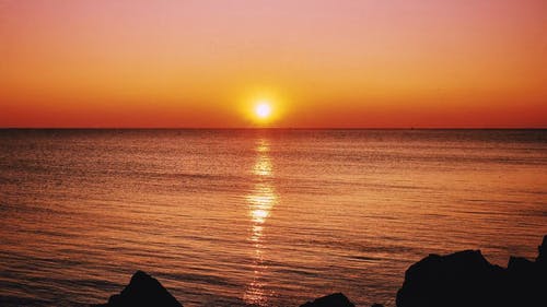 从多岩石的海岸海上地平线的日落美景 · 免费素材视频