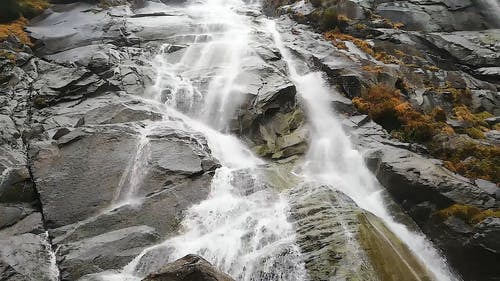 瀑布顺着山坡的悬崖岩石 · 免费素材视频