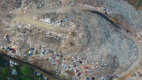 一个人从垃圾填埋场收集可回收物品 · 免费素材视频