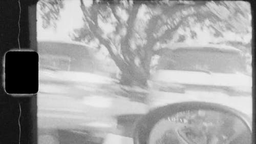 一个男人在城市附近驾驶一辆自上而下的跑车的老视频画面 · 免费素材视频