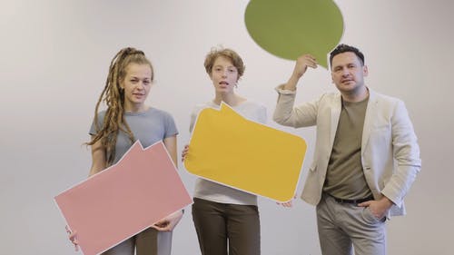 一群人嘴唇说话时拿着一个空白的声明板 · 免费素材视频