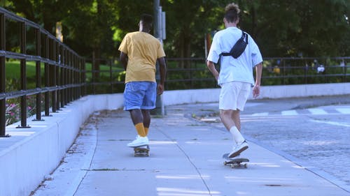 两名年轻男子在人行道上滑板 · 免费素材视频