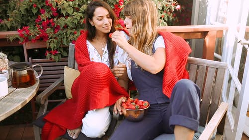 一对同性恋夫妇在他们的室外露台上吃新鲜水果 · 免费素材视频