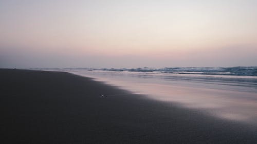 海浪在日落时冲到岸边 · 免费素材视频