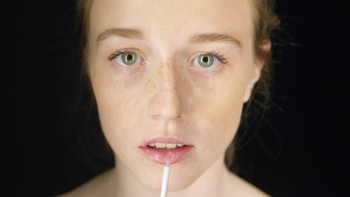 一个女人在她的嘴唇上涂上光泽 · 免费素材视频