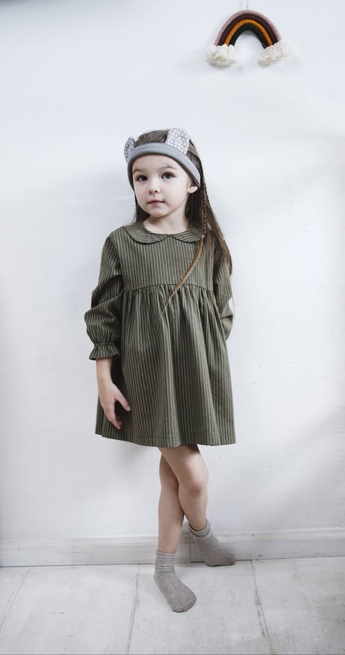摆在和穿一件可爱的衣服的小女孩 · 免费素材视频