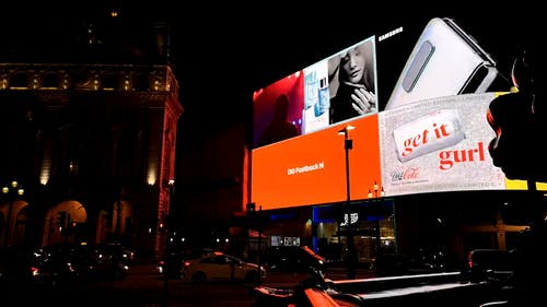 巨大的电子广告牌屏幕照亮了街道 · 免费素材视频