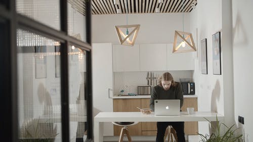 办公室厨房里的一个人在笔记本电脑上工作时吃早餐 · 免费素材视频