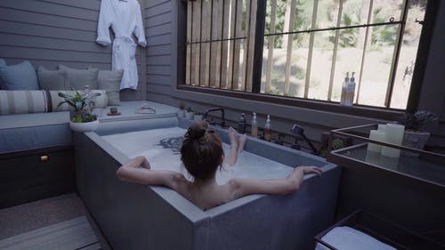 一个女人在浴缸里浸泡的背面 · 免费素材视频