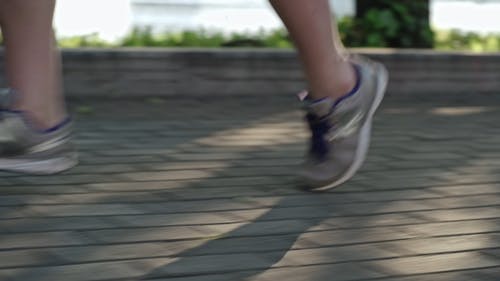 一个人在混凝土砖砌的路面上奔跑 · 免费素材视频
